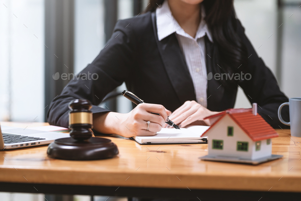 Close-up of woman lawyer hand holding a pen to taking notes real estate ideas sample house mallet em