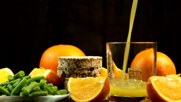 A Few Slices And A Whole Orange And Juice Are Poured Into A Glass And Green Beans