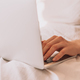 Lady working on a laptop in bed with white linens - PhotoDune Item for Sale