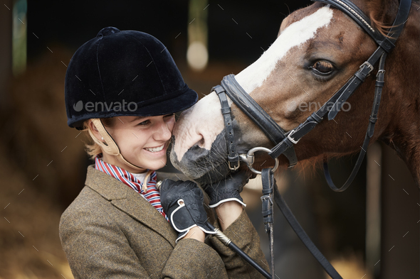 Teenager girl with horse in stable - Stock Photo - Images