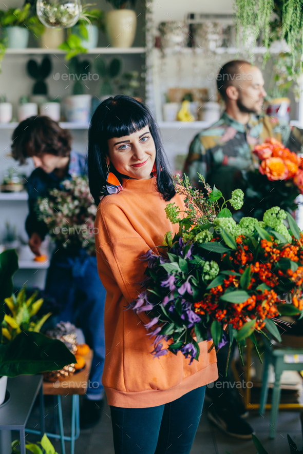 Woman working with florists in flower store - Stock Photo - Images