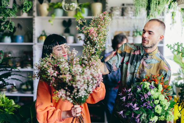 Woman working with florists in flower store - Stock Photo - Images