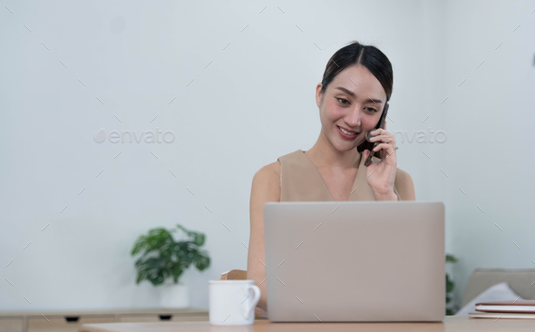 Smiling beautiful Asian businesswoman analyzing chart and graph showing changes on the market and - Stock Photo - Images