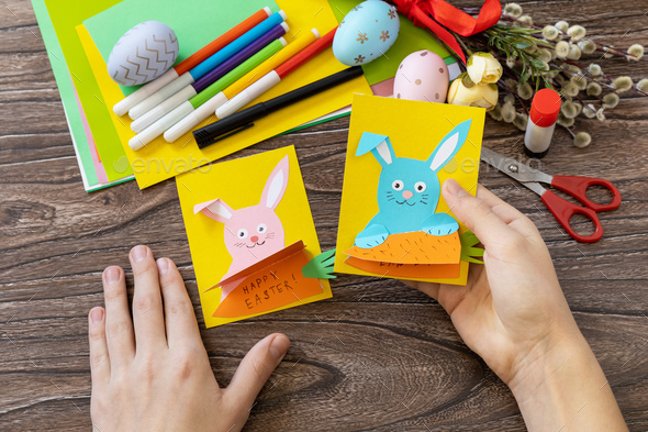 A child is holding an Easter congratulation card with Easter bunny. Handmade. - Stock Photo - Images