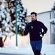 Dedicated athletic man jogging on snowy street in the city. - PhotoDune Item for Sale