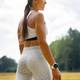 Rear view of a Smiling Female Athlete Listening Music While Exercising Outdoors - PhotoDune Item for Sale