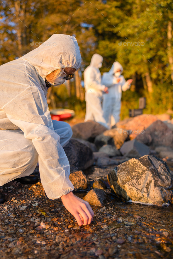 Team of scientists collecting water samples at seashore - Stock Photo - Images