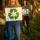 Smiling woman holding recycling symbol placard togheter with her team - PhotoDune Item for Sale