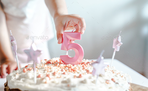 Big pink 5 number candle on homemade cake. Creative congratulations on five years for child girl.  - Stock Photo - Images