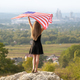 Young happy woman with long hair raising up waving on wind american national flag - PhotoDune Item for Sale