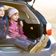 Two happy children boy and girl sitting together in a car trunk. - PhotoDune Item for Sale
