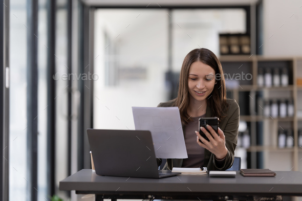 Business woman using smartphone for do math finance on wooden desk in office, tax, accounting - Stock Photo - Images