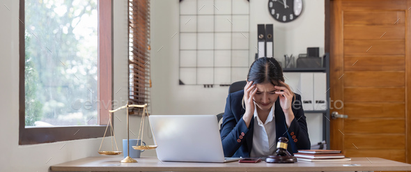 A young businesswoman lawyer is looking stressed as she works at her computer. consultant lawyer - Stock Photo - Images