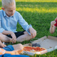 cute caucasian children sitting on grass in park having lunch eating pizza outdoors after school. - PhotoDune Item for Sale