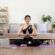 Millennial Asian woman meditating with trainer online on laptop at home - PhotoDune Item for Sale