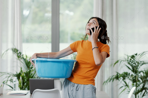 Woman collecting water leaking from the ceiling
