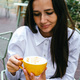 Pretty young brunette woman holding yellow coffee cup in restaurant.  - PhotoDune Item for Sale