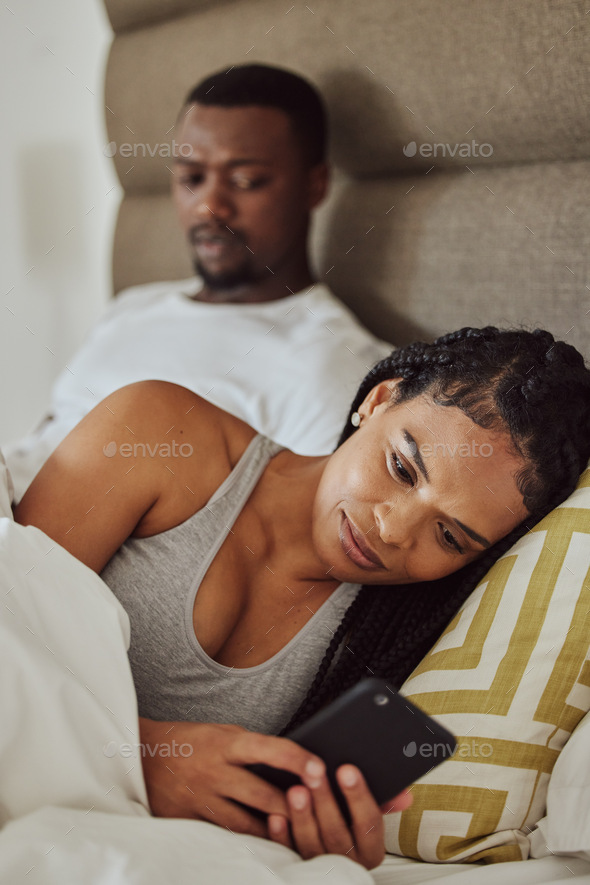 Couple in bed, black woman with smartphone and nosy man, cheating and suspicion for affair