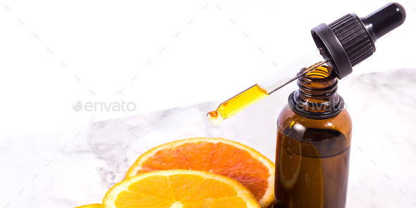 Vitamin C serum bottle with dropper on white marble background - Stock Photo - Images