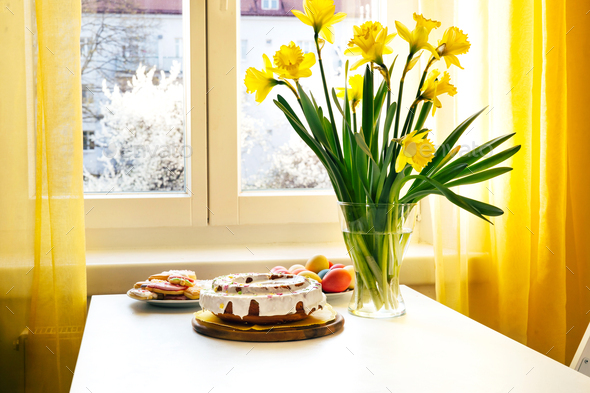 Easter cake, eggs and bunch of narcissus on a table - Stock Photo - Images