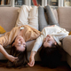 Happy european millennial ladies in sweaters lie on sofa, enjoy rest, communication and relax at - PhotoDune Item for Sale