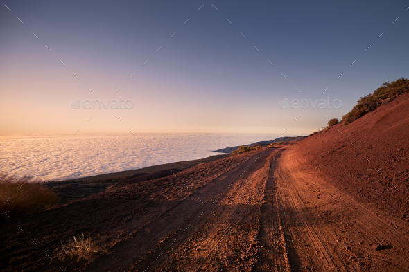 Dirt road in mountains above clouds - Stock Photo - Images