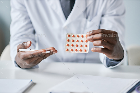 Close up African American doctor holding tablets to camera - Stock Photo - Images