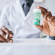 Close up black doctor holding bottle of pills to camera - PhotoDune Item for Sale