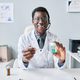 Black doctor holding bottle of pills wearing headset at workplace in office - PhotoDune Item for Sale
