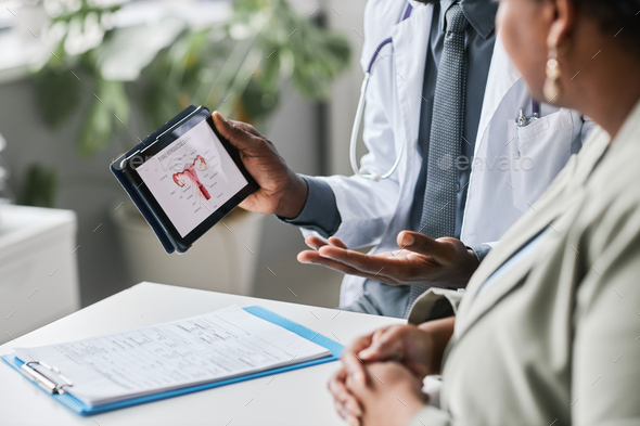 Close up doctor holding tablet with female reproductive health charts