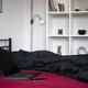 Laptop with black blank screen and smartphone on bed with viva magenta bed sheet. Home office - PhotoDune Item for Sale