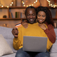 Happy black lovers shopping from home, using laptop, credit card - PhotoDune Item for Sale