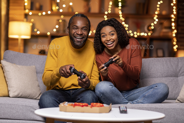 Cool african american couple playing video games at home - Stock Photo - Images