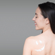 Cheerful young european naked female has cream smiley on skin, enjoy procedure, isolated on gray - PhotoDune Item for Sale
