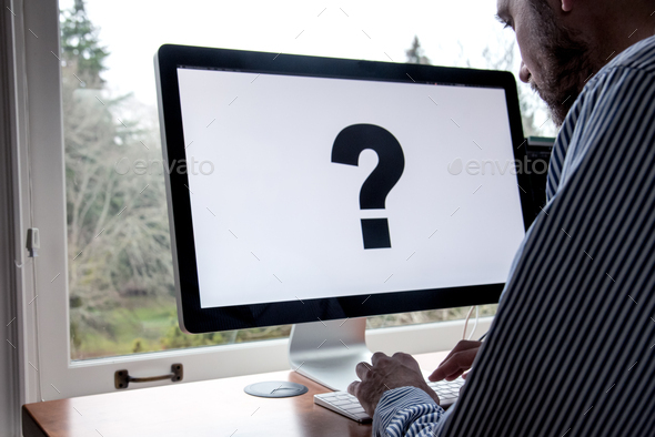 Using computer with large question mark on screen - Stock Photo - Images