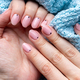 Female hands with trendy beautiful manicure - pink nude nails with black small dots - PhotoDune Item for Sale