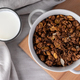 Organic homemade roasted granola cereal in bowl with glass of milk on wooden board - PhotoDune Item for Sale