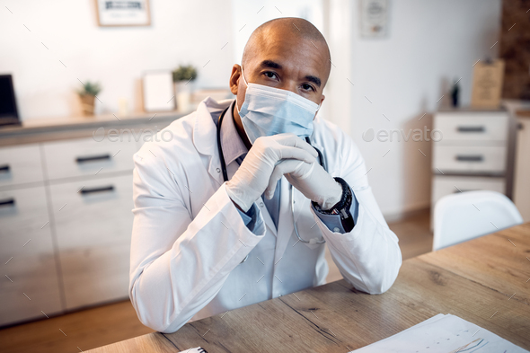 African American medical expert with protective face mask and doctor\'s office.