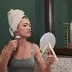 Young Woman Using Jade Facial Roller for Face and Neck Massage Sitting By the Bathroom Mirror Slow - VideoHive Item for Sale