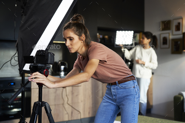 Two female women checking camera and lights before recording - Stock Photo - Images