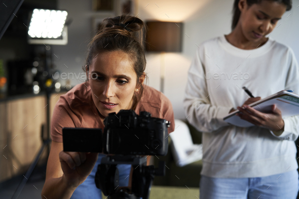 Two female women checking records on the camera and making notes - Stock Photo - Images