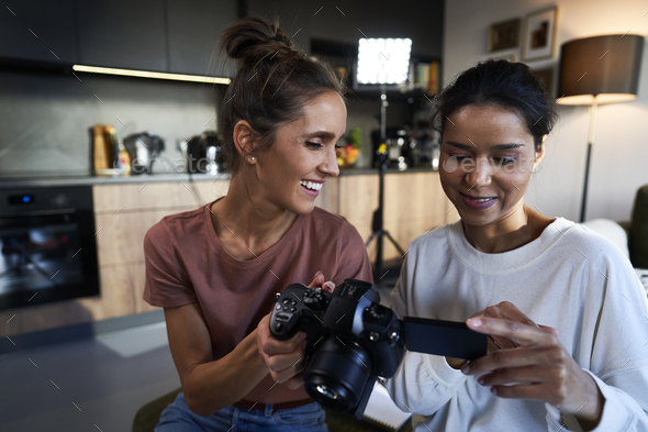 Two female women checking records on the camera - Stock Photo - Images