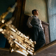 Pensive young saxophonist looking through window view from bottom - PhotoDune Item for Sale