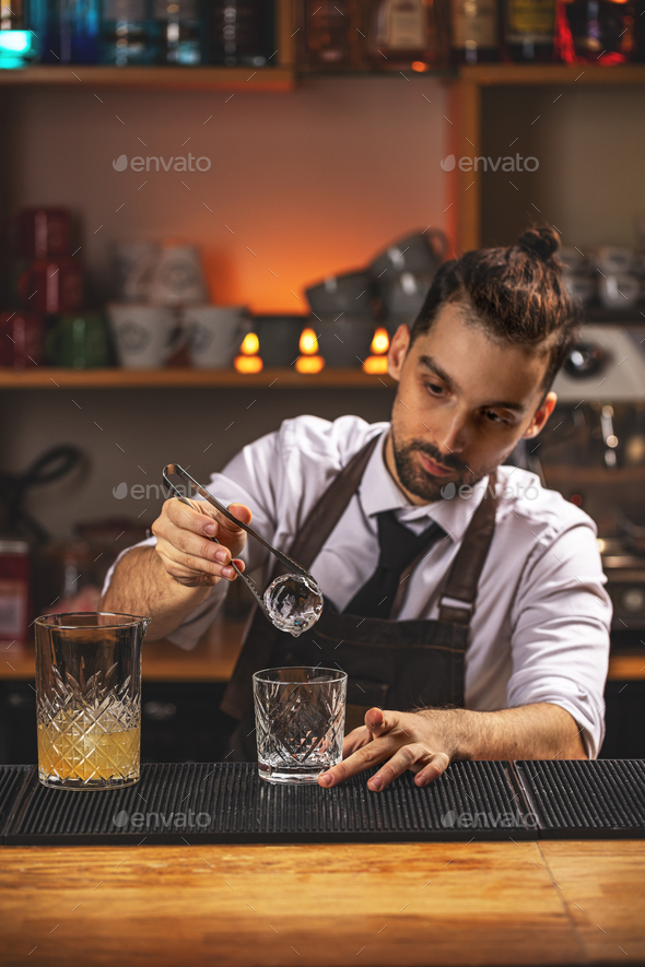 Barman is putting ice ball - Stock Photo - Images