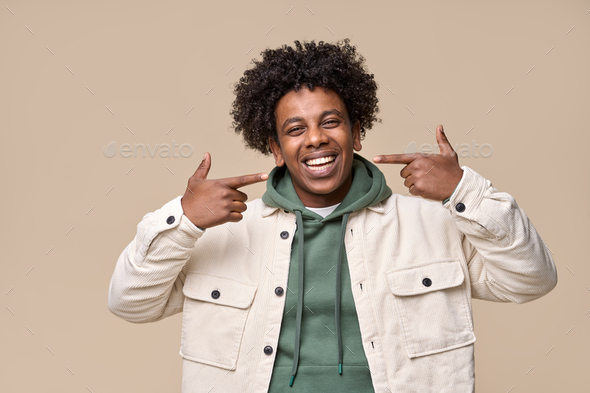 Smiling African guy pointing at dental white teeth advertising whitening. - Stock Photo - Images