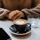 Girl in cafe waits for call from loved one over cup of coffee with heart shaped latte art foam - PhotoDune Item for Sale
