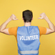 Man in a volunteer waistcoat pointing his back - PhotoDune Item for Sale