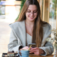 Smiling woman using the phone in a coffee shop. - PhotoDune Item for Sale