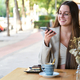 Smiling woman sending audio note with her phone in a coffee shop. - PhotoDune Item for Sale