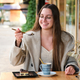 Woman eating a cake and drinking coffee in a cafe. - PhotoDune Item for Sale